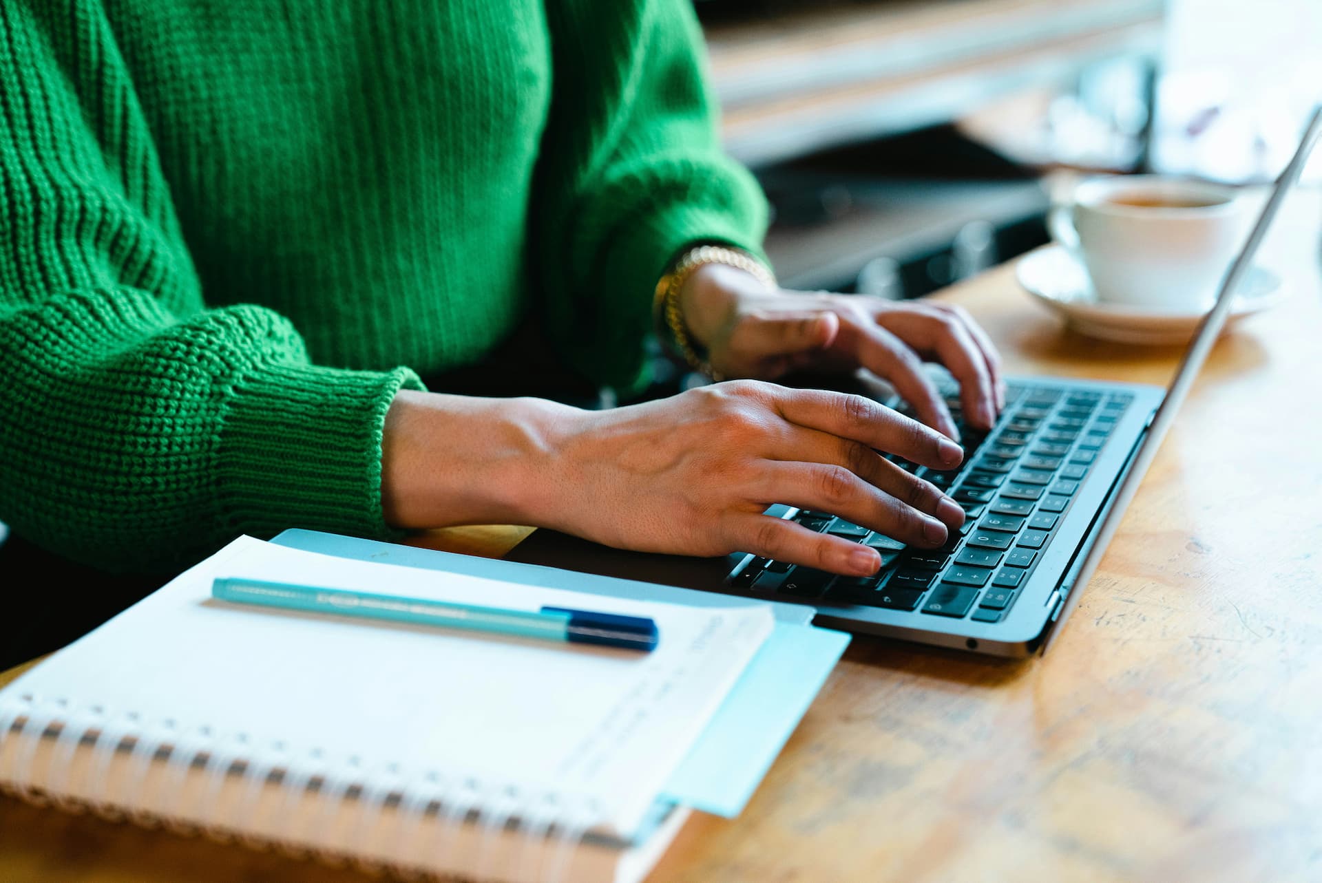 Person typing on a laptop beside documents while completing an online complaint form.